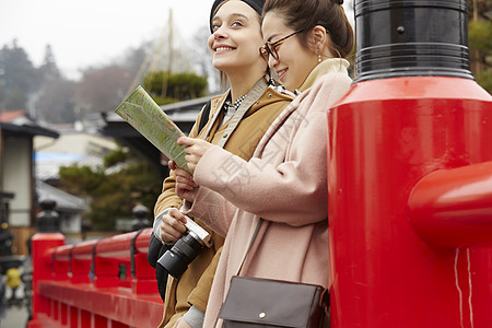 带着相机外国妇女和拿着地图的日本妇女在老街道采风岐阜县图片