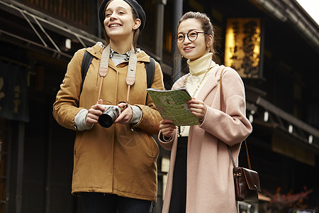  拿着导游手册的两位女性 图片