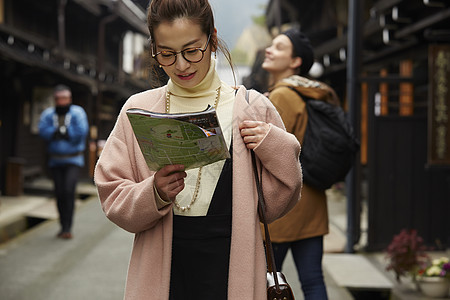 带着相机外国妇女和拿着地图的日本妇女在老街道采风岐阜县图片