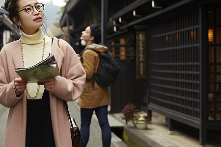 带着相机外国妇女和拿着地图的日本妇女在老街道采风岐阜县图片