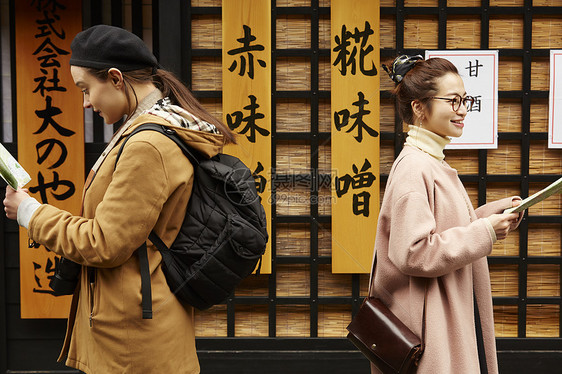 带着相机外国妇女和拿着地图的日本妇女在老街道采风岐阜县图片