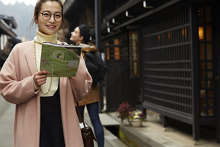 带着相机外国妇女和拿着地图的日本妇女在老街道采风岐阜县图片