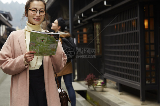 带着相机外国妇女和拿着地图的日本妇女在老街道采风岐阜县图片