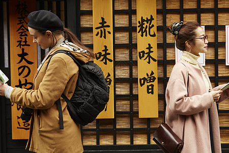 带着相机外国妇女和拿着地图的日本妇女在老街道采风岐阜县图片