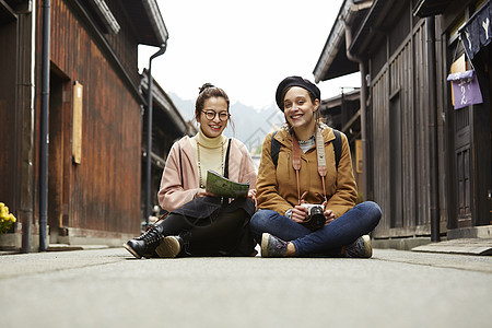 带着相机外国妇女和拿着地图的日本妇女在老街道采风岐阜县图片