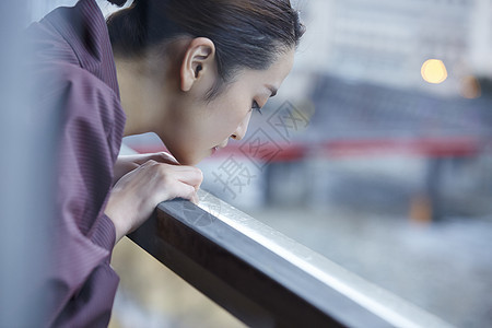 穿着现代和服趴在栏杆上向下看的女人图片