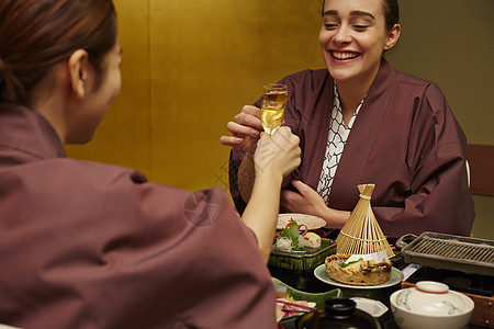 穿着现代和服的两个女人在享受美食图片