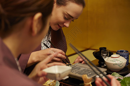 穿着现代和服的两个女人在享受美食图片