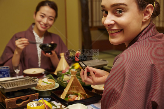 穿着现代和服享受美食的两个女人图片