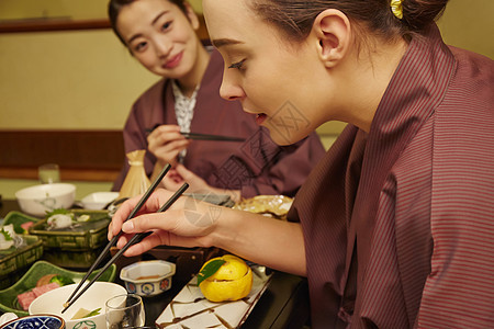 穿着现代和服享受美食的两个女人图片