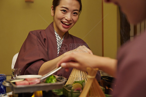 穿着现代和服享受美食的两个女人图片