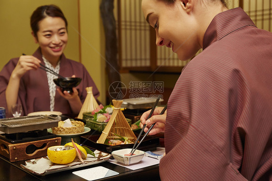 穿着现代和服享受美食的两个女人图片