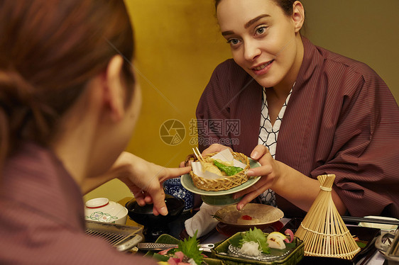 穿着现代和服享受美食的两个女人图片