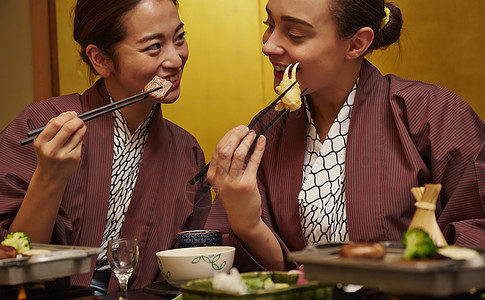 穿着现代和服享受美食的两个女人图片