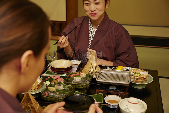 穿着现代和服享受美食的两个女人图片