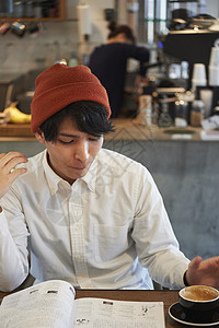在咖啡馆喝咖啡看杂志的男青年图片