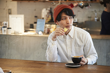 在咖啡馆喝咖啡吃甜品的男青年图片