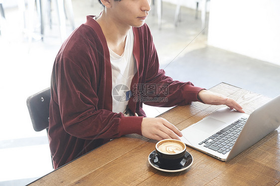 男性青年在咖啡店办公图片