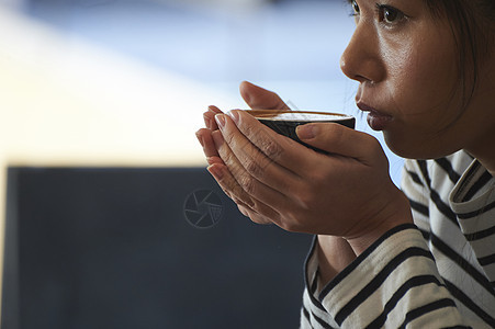 捧着一杯咖啡的女青年图片