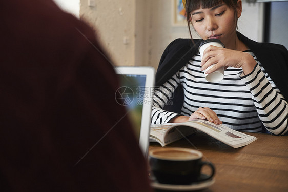 喝咖啡看杂志的年轻女性图片