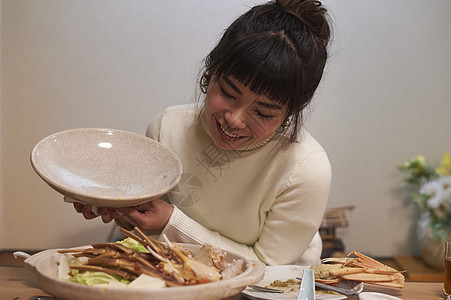 吃松叶蟹平底锅的妇女图片