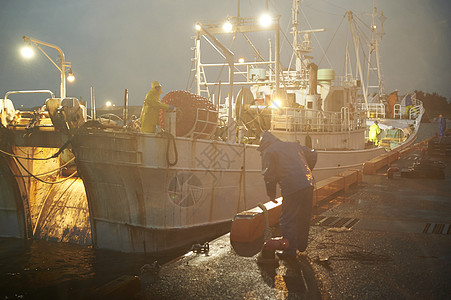 夜晚码头忙碌的渔民图片