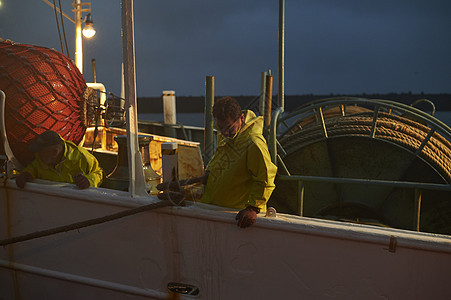 船上捕鱼的渔夫图片