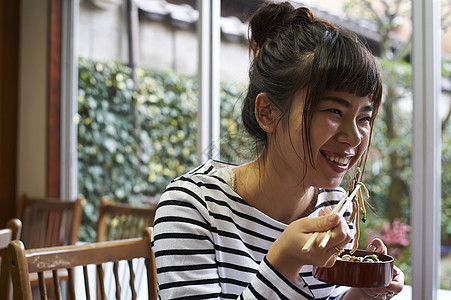 开心品尝美食的年轻女性图片