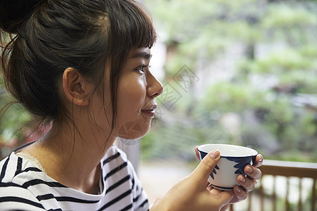 捧着热茶的年轻女性图片