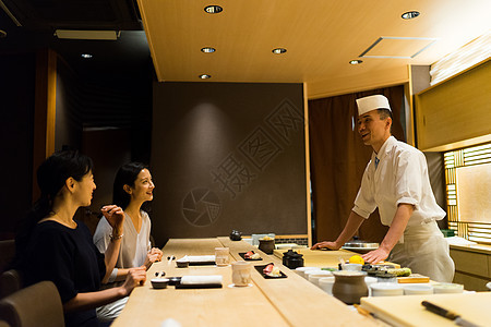 寿司店里的顾客和厨师图片
