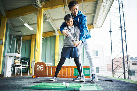 父亲手把手指导学习高尔夫的女孩图片素材