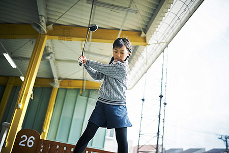 户外练习高尔夫挥动球杆的女孩图片
