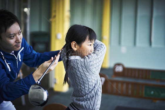 指导女孩学习高尔夫的父亲图片