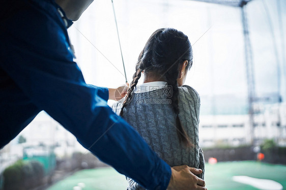 指导女孩学习高尔夫的父亲特写图片