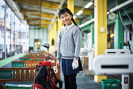 站在高尔夫球袋旁的女孩图片