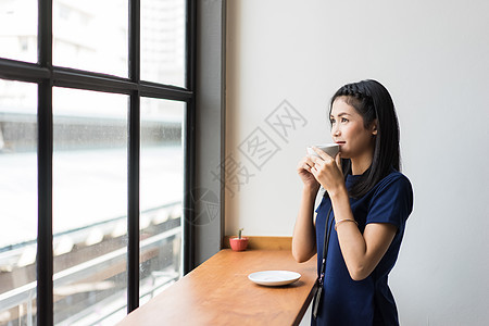 坐在窗边喝咖啡的女白领图片