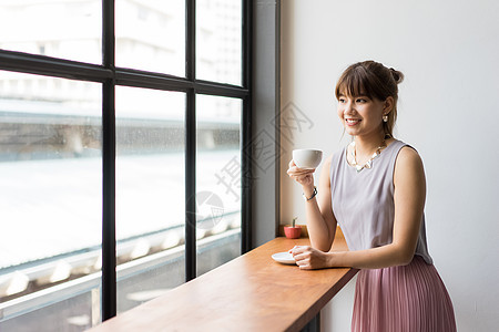 坐在窗边喝咖啡的女白领图片