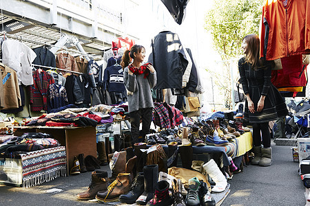 在特卖会上挑选商品的女人图片