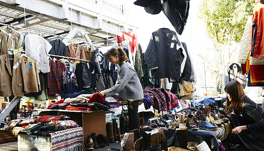 在集市上挑选衣服的女人高清图片