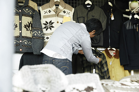 在跳蚤市场挑选衣服的男士图片