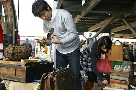 在跳蚤市场挑选物品的男生图片