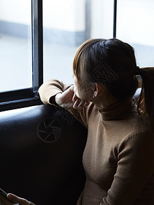 看向窗外思考的年轻女人图片