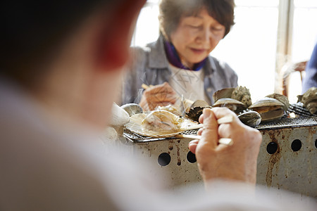 老年妇女享受海鲜烧烤图片