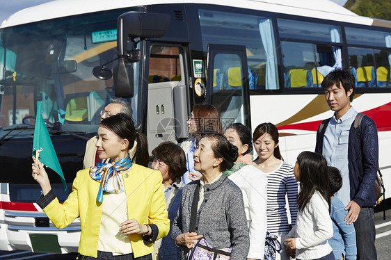 拿着旗帜带领旅游团的年轻导游图片