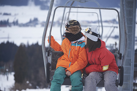  坐缆车准备滑雪的情侣图片