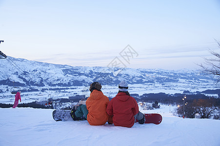  坐在滑雪场上的一对情侣图片