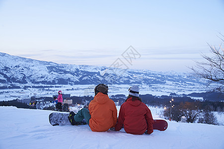   坐在滑雪场上的一对情侣图片