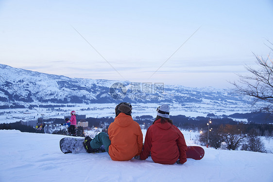   坐在滑雪场上的一对情侣图片