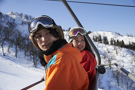 缆车上身着滑雪服装的情侣高清图片