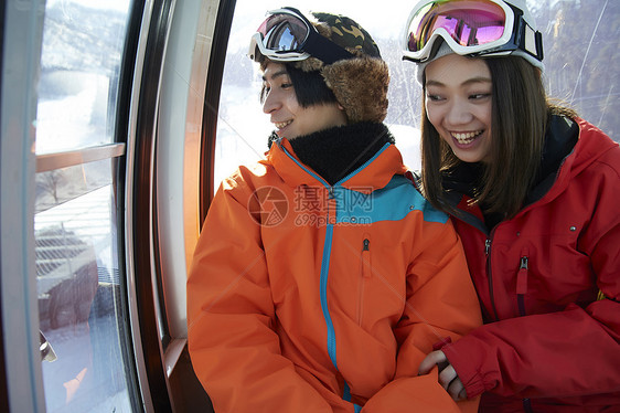 滑雪场坐缆车的一对情侣图片